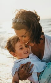 photo of mother and child beside body of water