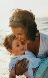 photo of mother and child beside body of water